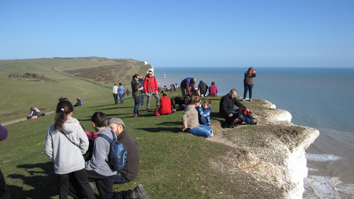 People near the edge of the chalk cliffs at Beachy Head