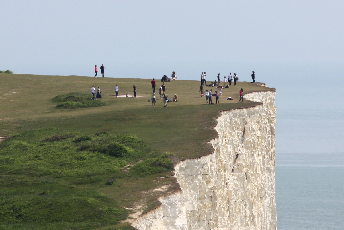 People near the edge of the cliff at Birling Gap
