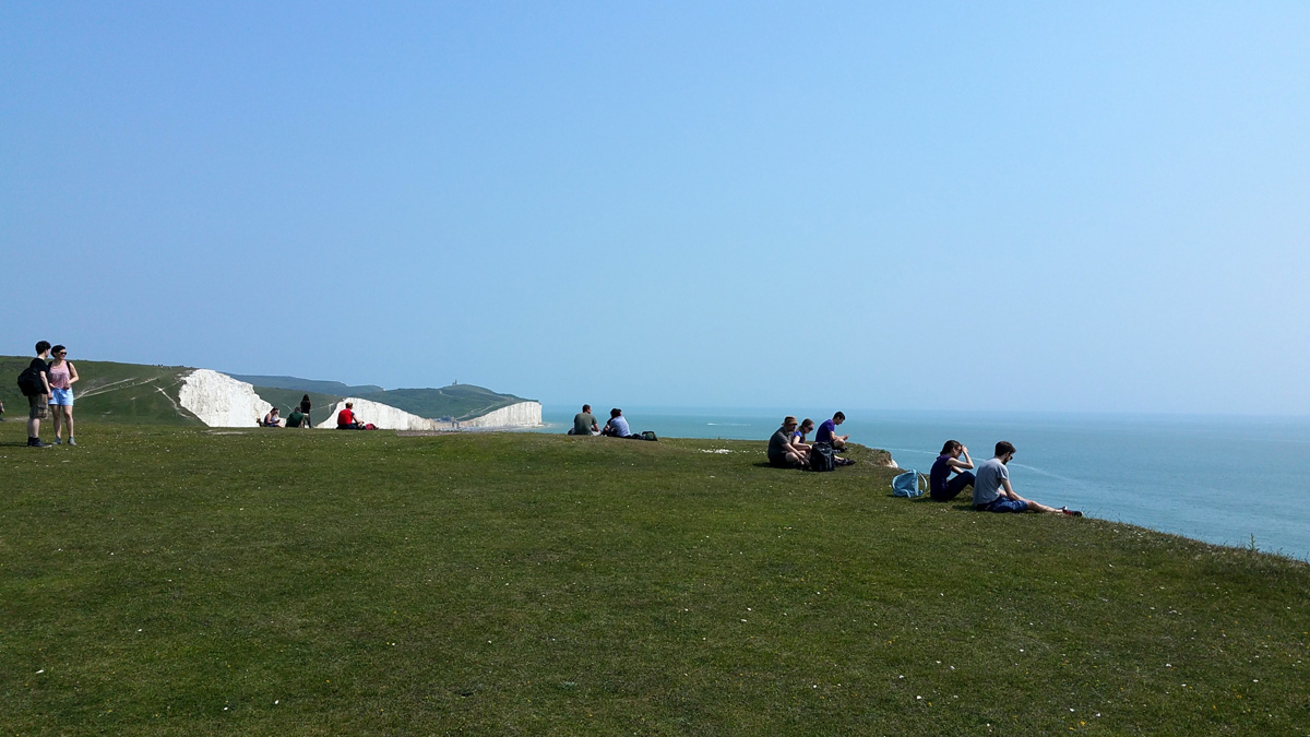 people-sitting-along-the-edge-of-the-cliff